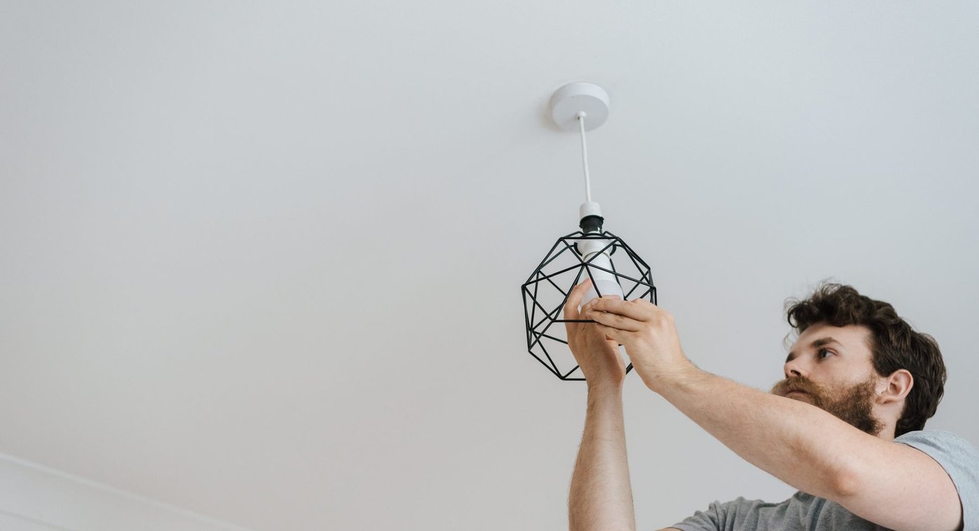 Installing a black geometric pendant light on a white ceiling